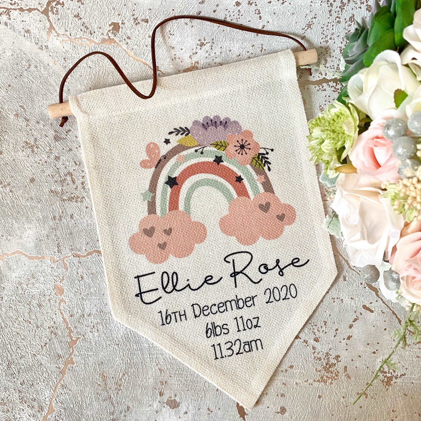 linen flag with floral rainbow design printed on with a name and birth details below