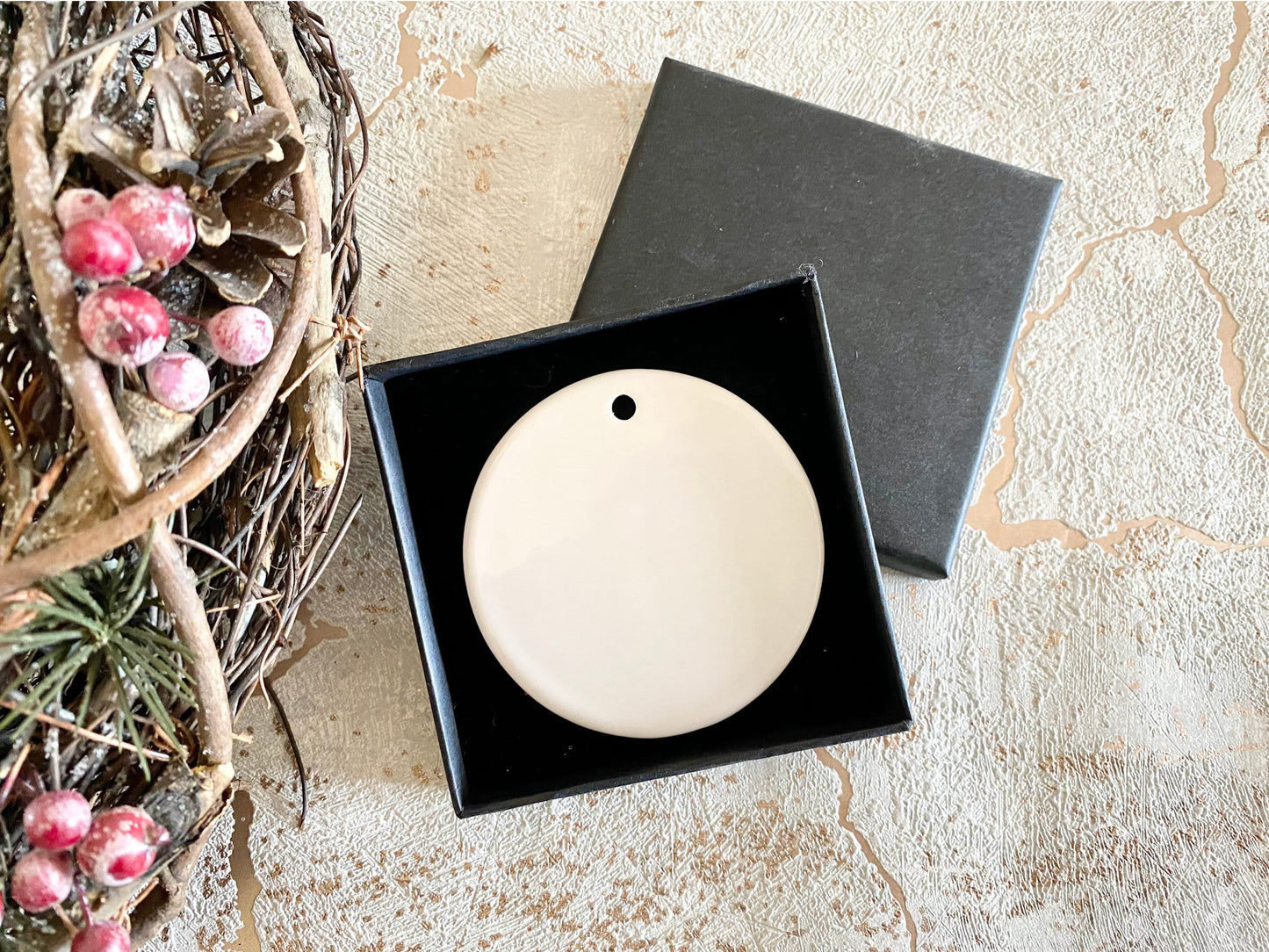 black gift box with flat ceramic bauble inside