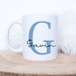 white mug on a log slice has a large blue letter G printed on it with the name Gavin printed over in a black script font