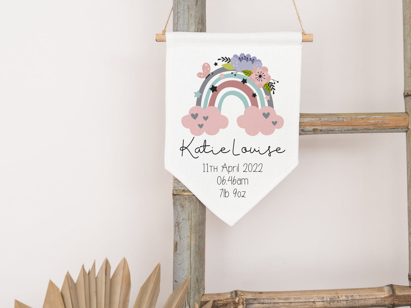 linen flag with floral rainbow design printed on with a name and birth details below