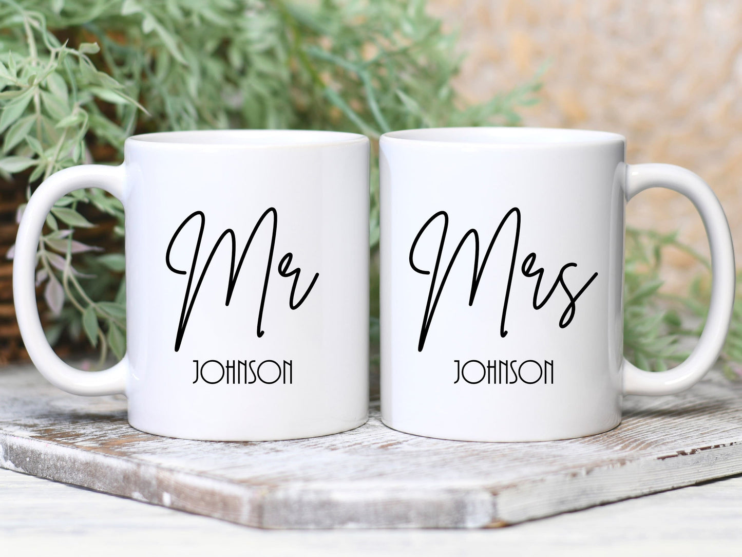 set of two white mugs. One has Mr printed on in a script font with a surname below. The other has Mrs printed on