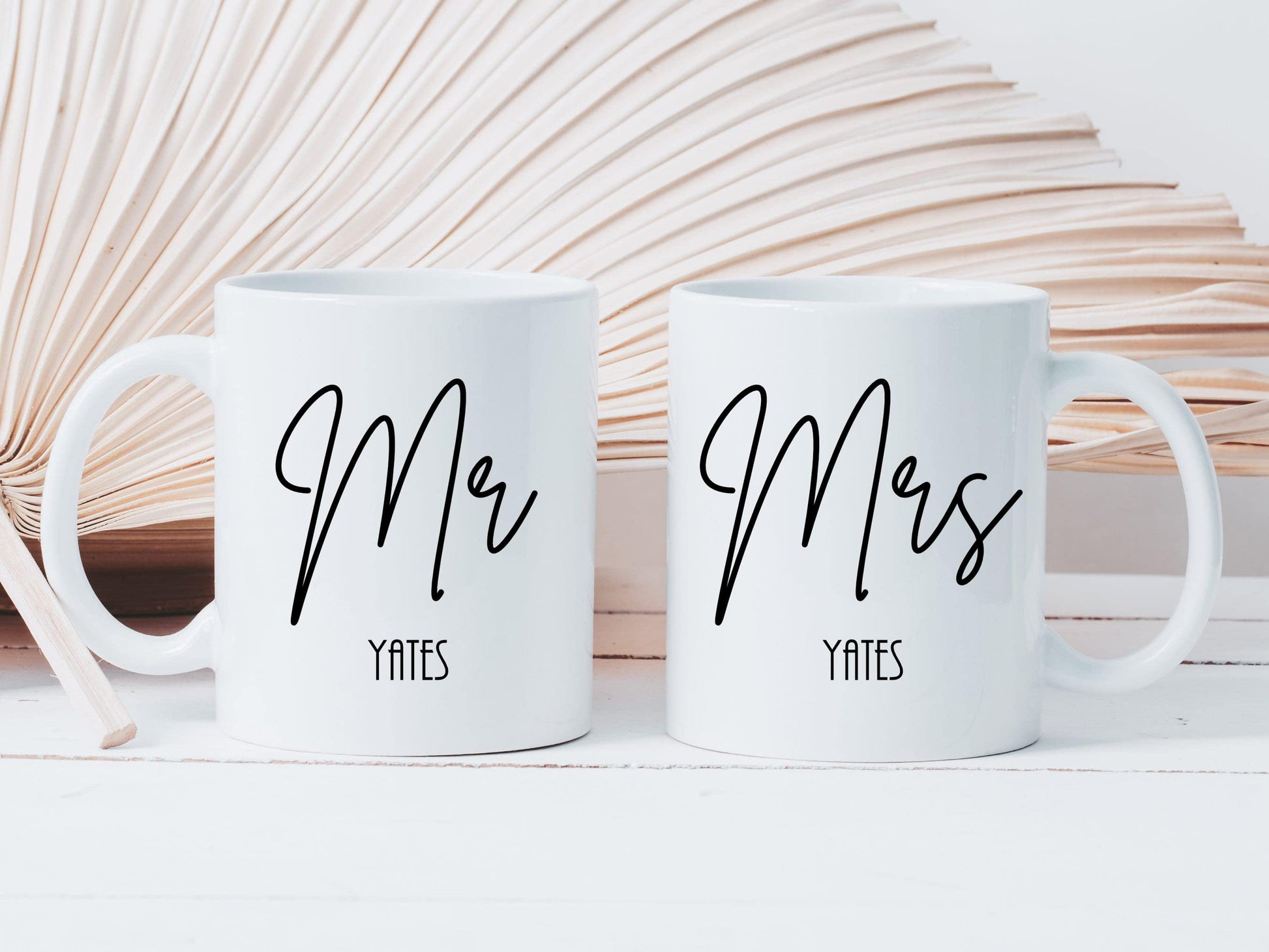 set of two white mugs. One has Mr printed on in a script font with a surname below. The other has Mrs printed on