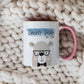 cute bear design printed on a white mug with pink handle. There is Daddy bear printed above the design over a blue banner. The mug is on a cream knitted blanket
