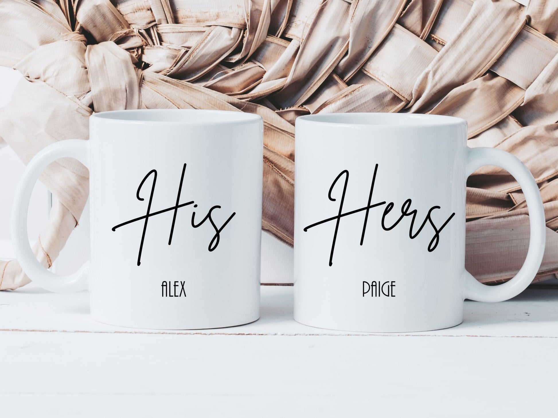 set of two white mugs. One has the text His in a script font with a name below and the other has Hers with a name below. 